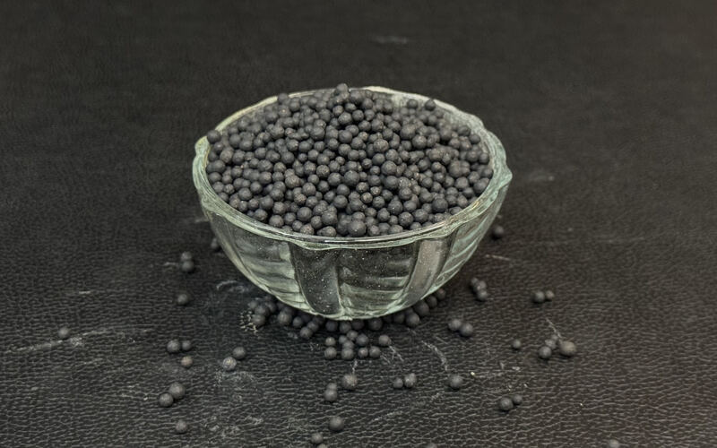 Black bentonite granules in a glass bowl
