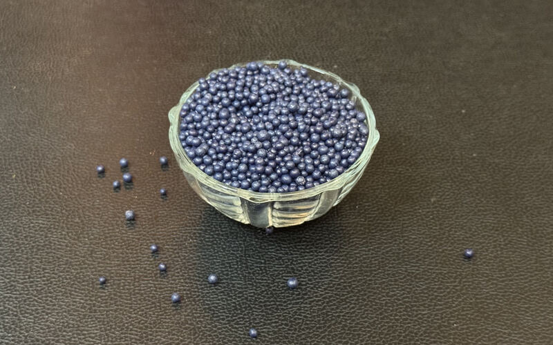 Blue bentonite granules in a glass bowl