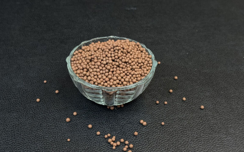 Brown bentonite granules in a glass bowl