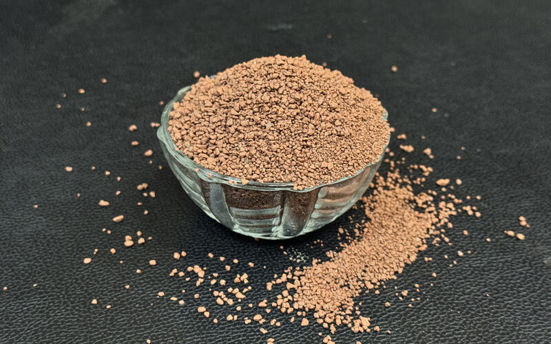 Brown bentonite pellets heaped in a glass bowl
